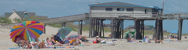 Sunbathers near a fishing pier